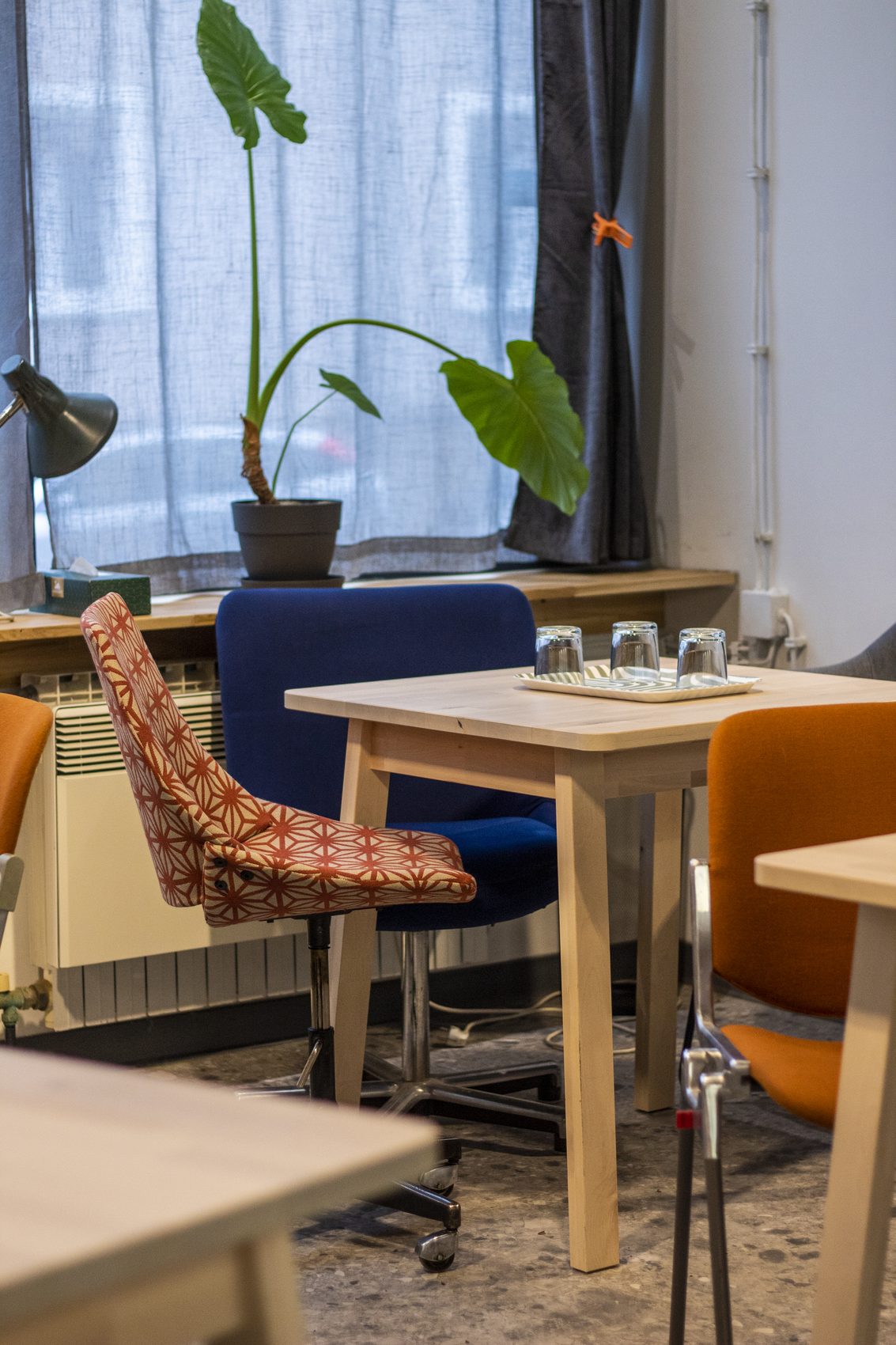 Work corner by the window with blue and orange chairs